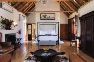 Adara Palmiet Valley Luxurious Boutique Farm Hotel في بارل: غرفة نوم مع سرير وغرفة معيشة