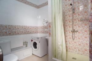 a bathroom with a washing machine and a shower at Grand Alatau in Astana