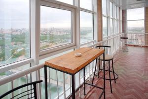 a room with a wooden table and some windows at Grand Alatau in Astana