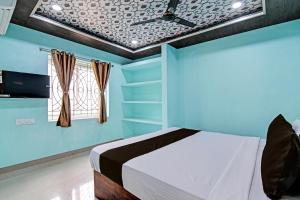 a blue bedroom with a bed and a window at OYO Raj Residency in Narendrapur