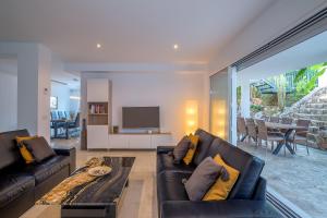 a living room with two black couches and a television at Villa Jazmin in Mijas Costa