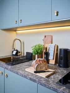 um balcão de cozinha com um pão numa tábua de cortar em Hidden Garden Apartments em Lódź