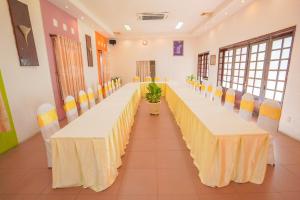 a long banquet hall with long tables and chairs at Nhà Hàng Khách Sạn Hòa Bình 2 in Long Xuyên