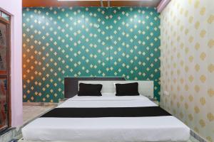 1 dormitorio con 1 cama con pared verde en OYO C.M Paradise, en Lucknow