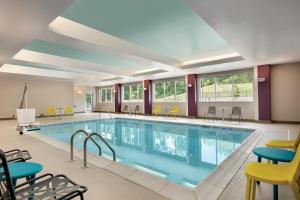 uma grande piscina interior com cadeiras e mesas em Home2 Suites By Hilton Easton em Easton