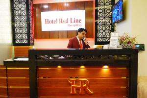 Ein Mann, der am roten Empfang des Hotels telefoniert. in der Unterkunft Hotel Red Line in Islamabad
