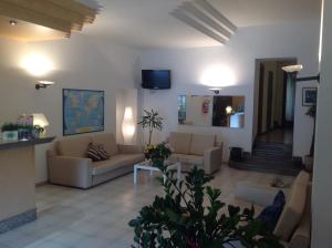 a living room with couches and a tv and stairs at Hotel Smeraldo in Brenzone sul Garda