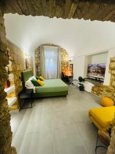 una camera con un letto verde e una parete in pietra di Casa Soderini a Tarquinia