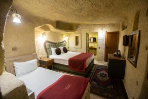 a hotel room with two beds and a television at Antique House Cappadocia in Nevsehir