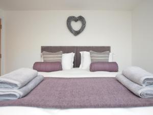 a bedroom with a bed with a heart sign on the wall at 3 Bed in Westward Ho 76533 in Northam