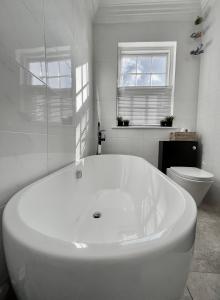 a white bathroom with a tub and a toilet at The Townhouse Central York in York