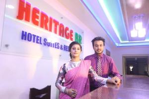 Un uomo e una donna in piedi di fronte a un hotel di Heritage B.R Hotel Suites and Restaurant a Chittagong