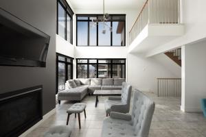 a living room with a couch and a tv at Auberge de la Montagne Coupée in Saint-Jean-de-Matha