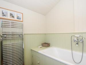 un bagno con doccia e vasca da bagno di Lowen Cottage a Boscastle Altre 14 foto