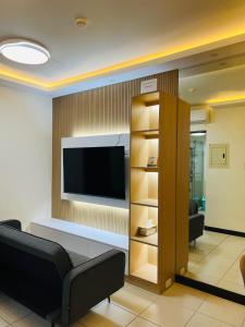 een woonkamer met een flatscreen-tv aan de muur bij Estellar Resort Condotel in Manilla