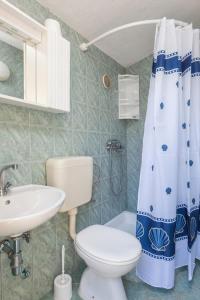 a bathroom with a toilet sink and a shower curtain at Holiday home Sweet Shelter with jacuzzi in Živogošće