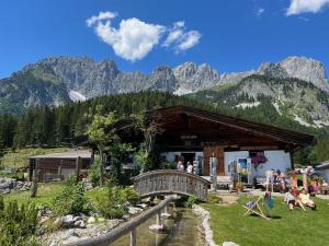 a building with a bridge and mountains in the background at CHALET BELLE WILD by Belle Stay in Going am Wilden Kaiser