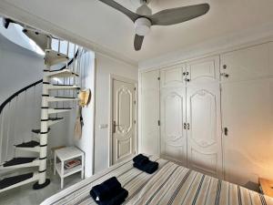 Una escalera en una habitación con ventilador de techo en Coqueto ático de playa, en Fuengirola