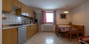 a kitchen and dining room with a table and a kitchen and a kitchen at Casa Davarda in Vigo di Fassa