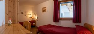 sypialnia ze stołem, łóżkiem i oknem w obiekcie Casa Davarda w mieście Vigo di Fassa