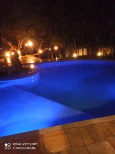 uma piscina azul à noite com luzes em Pousada Jacarandá by Rivaj em Trancoso