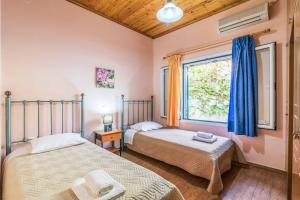 two beds in a room with a window at Villa Yiannakis in Nisakion +21 photos