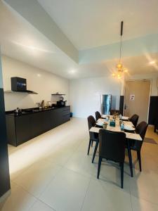 ein Esszimmer mit einem Tisch und Stühlen sowie eine Küche in der Unterkunft Reizz Residence by Elysium in Kuala Lumpur