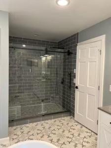 a bathroom with a shower with a glass door at Mountain Road Lodge in Tannersville +19 photos