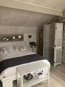 a bedroom with a white bed and a white table at Villa au coeur de la vallée in Thyez
