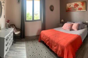 a bedroom with a bed with a red blanket and a window at Villa au coeur de la vallée in Thyez