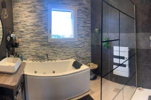 a bathroom with a tub and a glass shower at Villa au coeur de la vallée in Thyez +20 photos