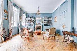 salon z niebieskimi ścianami i krzesłami w obiekcie Au pied de la tour Eiffel w Paryżu