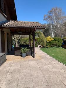a wooden pergola on the side of a house at Villa au coeur de la vallée in Thyez