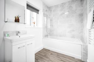 un bagno bianco con vasca e lavandino di 2 Bedroom - Deluxe Apt with Free Private Parking - Netflix & Wifi - Top Rated - 52C a Sleightholme