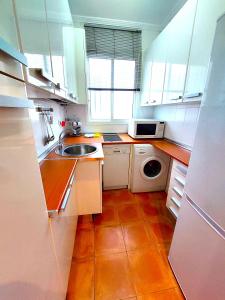 a small kitchen with a sink and a microwave at Maravilla Apartment in Seville