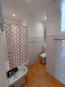 a bathroom with a toilet and a shower curtain at Maravilla Apartment in Seville