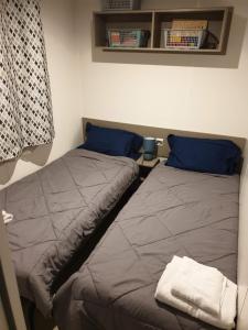 two beds sitting next to each other in a bedroom at Mobile home 6 personnes in Sainte-Reine-de-Bretagne