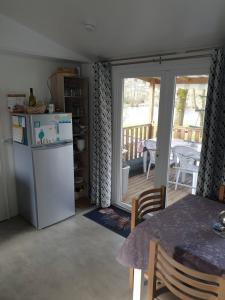 a kitchen with a refrigerator and a table and a dining room at Mobile home 6 personnes in Sainte-Reine-de-Bretagne