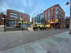 a person walking a dog on a city street at 2 Bed Flat Centre of Lace Market in Nottingham