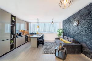 a large living room with a couch and a kitchen at Skyline Sunset View -XCity Tower - By OpenHouse apartments in Timişoara