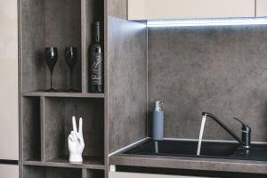 a kitchen with a sink and a shelf with utensils at Skyline Sunset View -XCity Tower - By OpenHouse apartments in Timişoara +43 photos