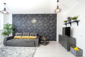 a living room with a couch and a wall at Skyline Sunset View -XCity Tower - By OpenHouse apartments in Timişoara