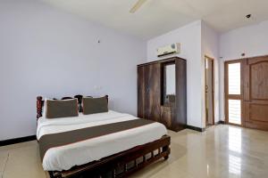 1 dormitorio con 1 cama grande en una habitación en Collection O KMM Kushi Resort, en Gundlupet