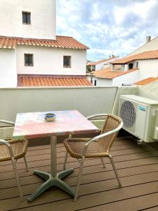 einen Tisch und zwei Stühle auf einem Balkon mit einem Tisch in der Unterkunft Hotel Lou Marquès in Saintes-Maries-de-la-Mer