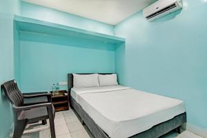 a blue bedroom with a bed and a chair at OYO HOTEL NANDAN in Bhubaneshwar