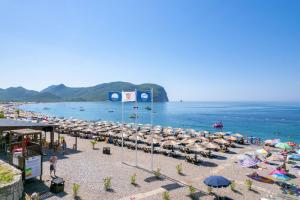 a beach with a bunch of umbrellas and the ocean at Apartments Villa Marija in Petrovac na Moru