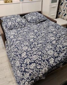 a bed with a blue and white blanket on it at F2 4 pers 2lits proche 5 min aéroport Orly Chez Sandro et Abby in Athis-Mons