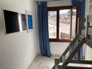 a room with a bed and a window with blue curtains at B&B Premium in Premia de Dalt