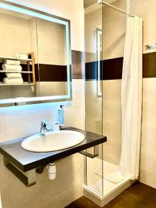 a bathroom with a sink and a shower at Hotel Lou Marquès in Saintes-Maries-de-la-Mer