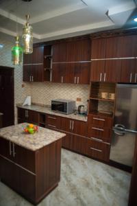 a kitchen with wooden cabinets and a granite counter top at Enny'scourt Service Apartment in Akure